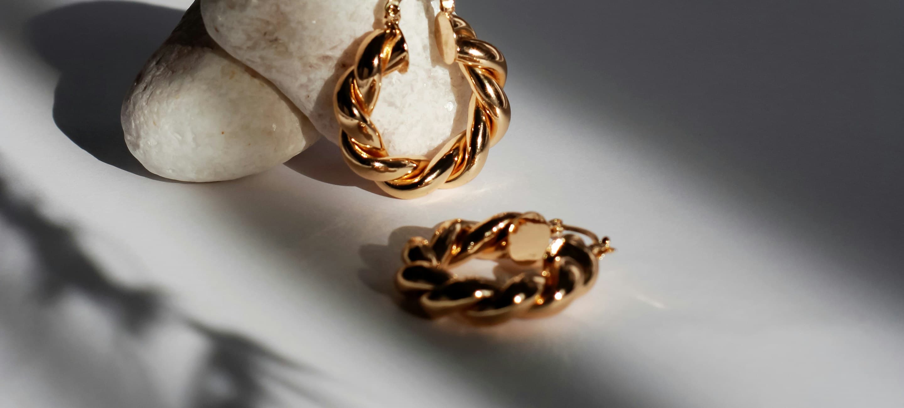 Twisted gold hoop earrings in soft daylight